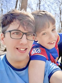 a man and his son are taking a selfie in the woods